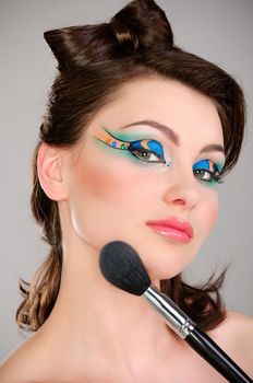 Beautiful girl makes a makeup studio shot