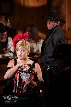 Pretty showgirl cheats in card game as sheriff watches