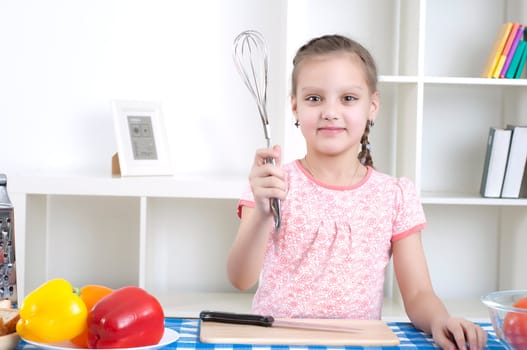 Beautiful girl holding a mixer, work in the kitchen