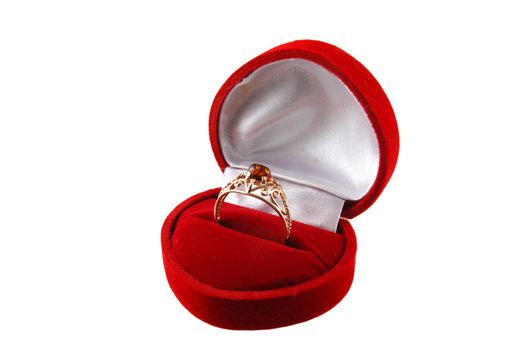 Gold ring with amber in red heart shape jewelry box on white background