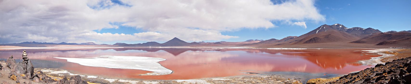 Panorama of the Red Lagoon, or Laguna Colorada, on the Altiplano near Uyuni inside Eduardo Avaroa National Reserve in Bolivia at 4300 m above sea level.  The red color of the water is caused by sediments and algae. The white part is borax salt.