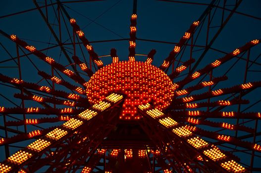 The central part of the Ferris wheel with a lit illumination.