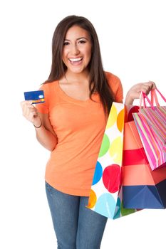 Beautiful Happy smiling young woman on shopping spree with credit card lastic money carrying colorful bags with merchandise presents, isolated.