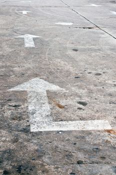 Old white arrow marking on road