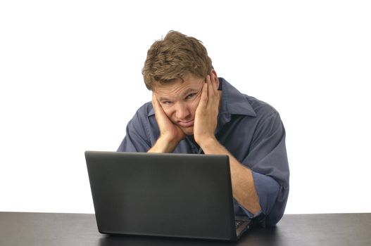 Man with look of disgust sits at computer with face in hands