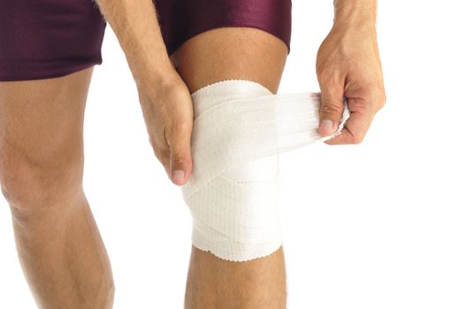 Male athlete wraps knee injury with bandage