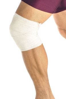 Leg of male athlete with bandaged knee as he runs