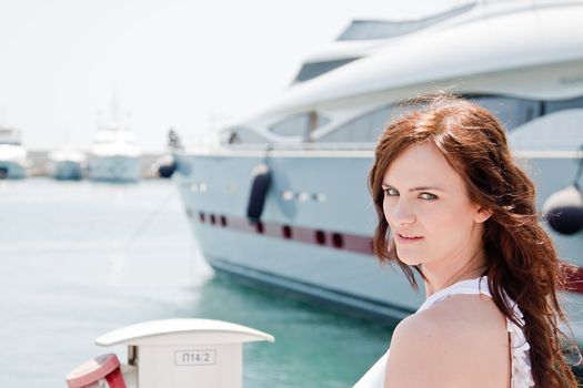 Portrait of a young and beautiful girl in the background of a large ocean liner