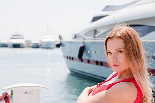 Portrait of a young and beautiful girl in the background of a large ocean liner