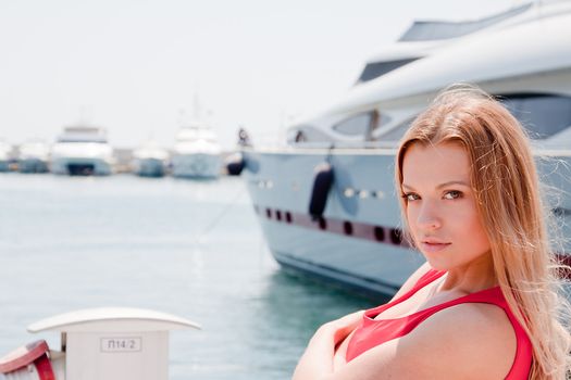 Portrait of a young and beautiful girl in the background of a large ocean liner