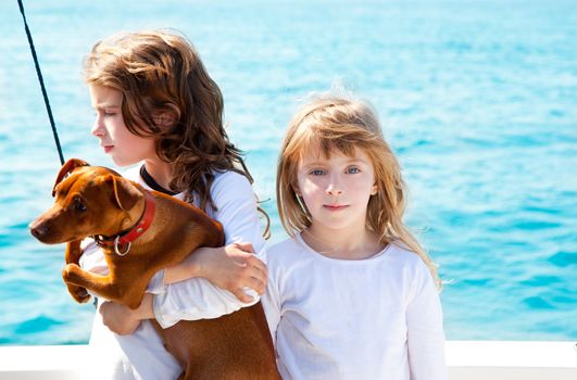 sister kid girls with dog mini pinscher on the sea view from a boat