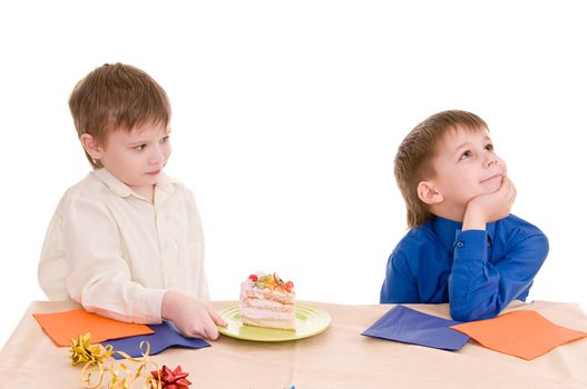 The boy gives a piece of cake to another boy