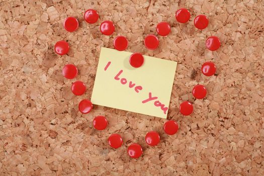 a valentine heart made of thumb tacks on a corkboard...........