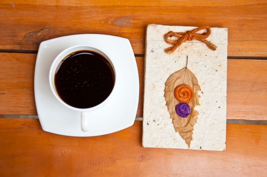 blank paper and black coffee on wood background