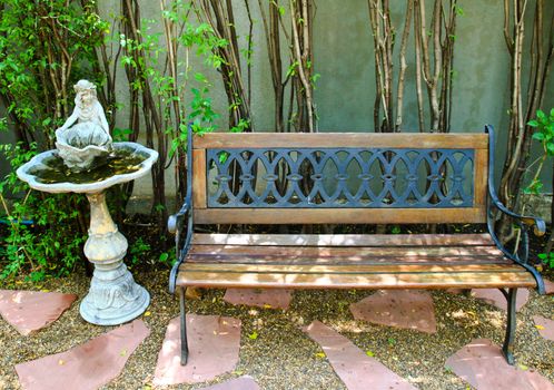 Bench and old fountain in garden