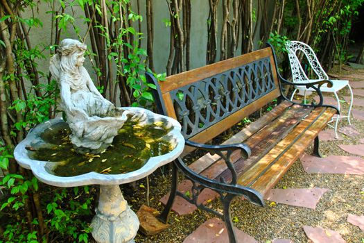 Bench and old fountain in garden