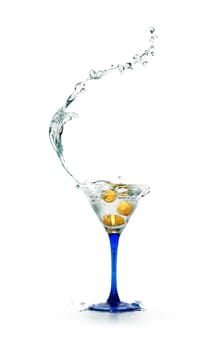 Stylish martini glass with splashing liquid and olives on white background