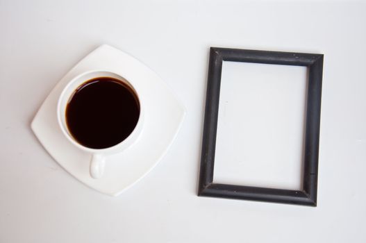 Black coffee and blank frame on white background