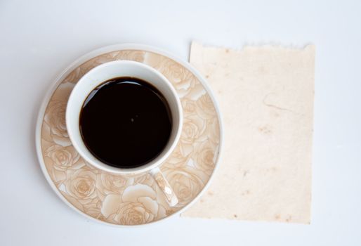 Blank paper and black coffee on white background