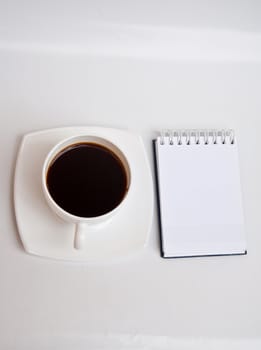 Blank paper and black coffee on white background