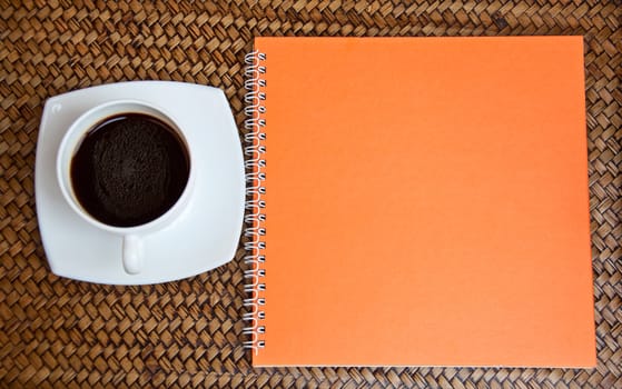orange notebook and coffe