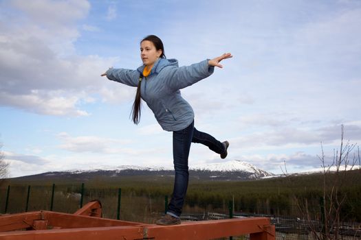 girl doing gymnastic element of balance on one leg on the balance beam