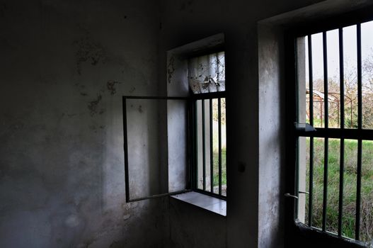 Barred door and windows in abandoned house interior.