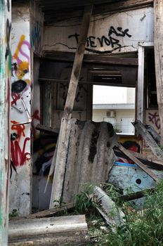 Broken cement asbestos roofing in derelict house. Hazardous waste in urban area.
