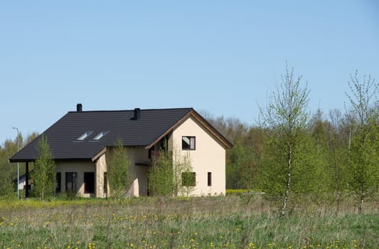 Modern apartment house on a background of a green grass and trees