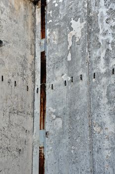 Concrete factory wall and rusty pipe. Industrial background.