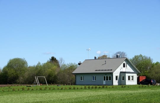 The house and field on a background of the sky