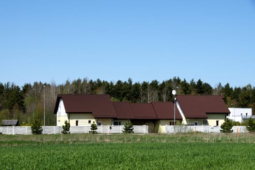 The long rural house and green field