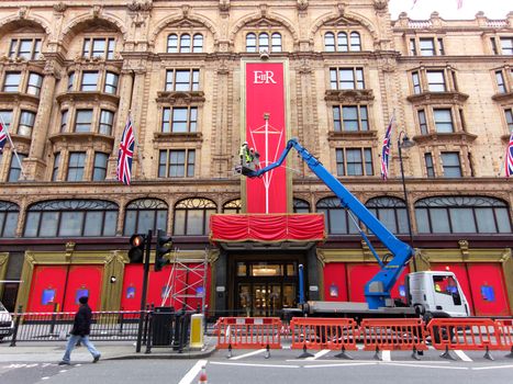 LONDON, UK - MAY 15: Workers put the last touch to the special Queen's Diamond Jubilee decoration on Harrods facade on May 15, 2012 in London.