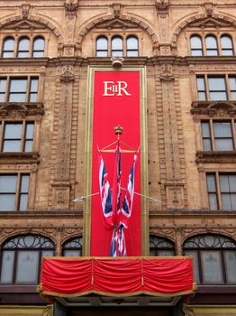 LONDON, UK - MAY 15: Workers put the last touch to the special Queen's Diamond Jubilee decoration on Harrods facade on May 15, 2012 in London.