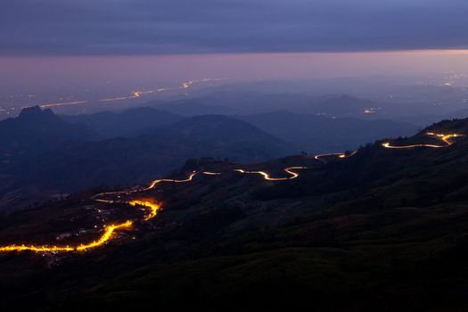 Car light in night on road in mountain.