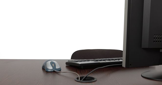 Image of an empty office desk with a lot of copy space behind it on the white wall.