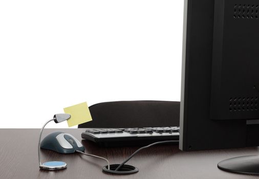 Image of an empty office desk with a blank yellow post-it.