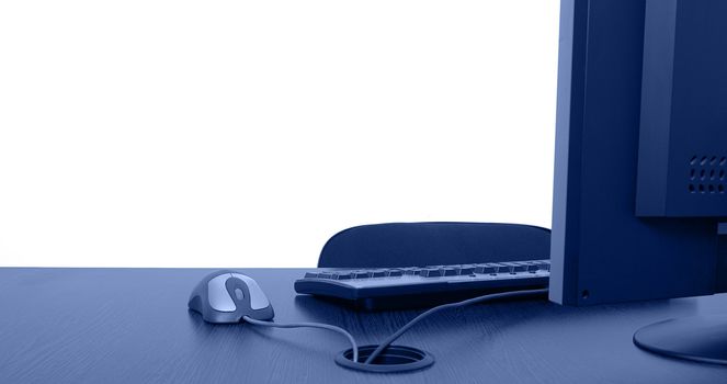 Image of an empty office desk with a lot of copy space behind it on the white wall.