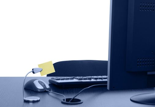 Image of an empty office desk with a blank yellow post-it.