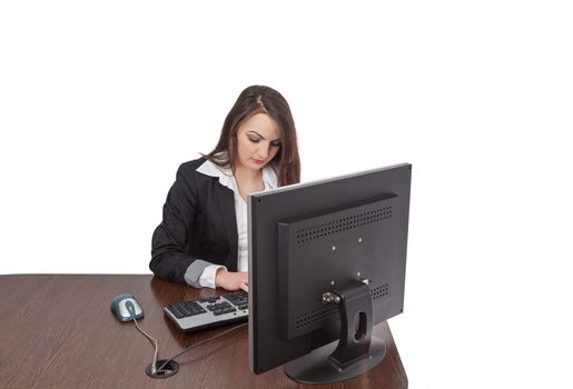 Image of a young brunette woman working on a computer at her desk, isolated against a white background.