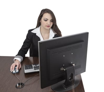 Image of a young brunette woman working on a computer at her desk, isolated against a white background.