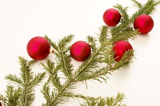 Border of red christmas garland with baubles and ribbons on white.