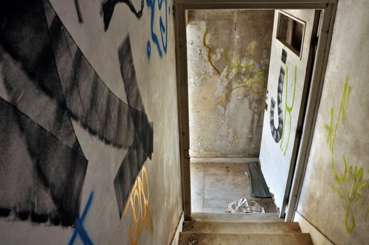 Painted arrow on staircase pointing to exit door in an abandoned house.