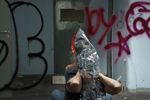 Distorted man emerging through broken glass mirror in abandoned interior.