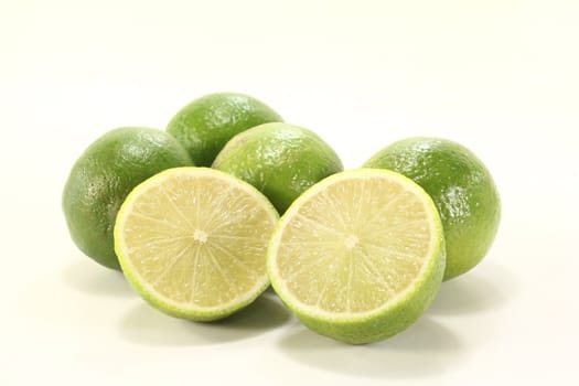 fresh green sliced and whole limes on a bright background