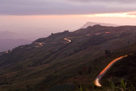 Car light in night on road in mountain.