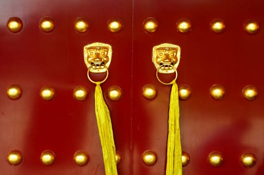Traditional Chinese ancient red door with golden doorknobs