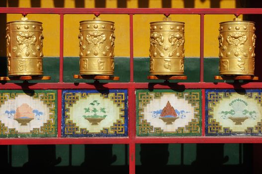 Golden Tibetan prayer wheels in a lamasery