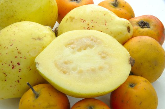 Several guava and tejocote fruit on white