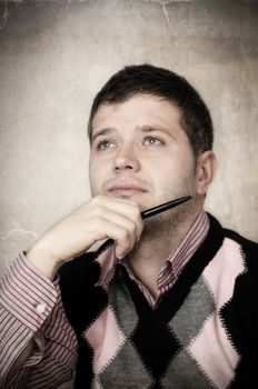 Vintage portret of a young man thinking and looking up-NOTE:Texture was added to simulate an old photo.